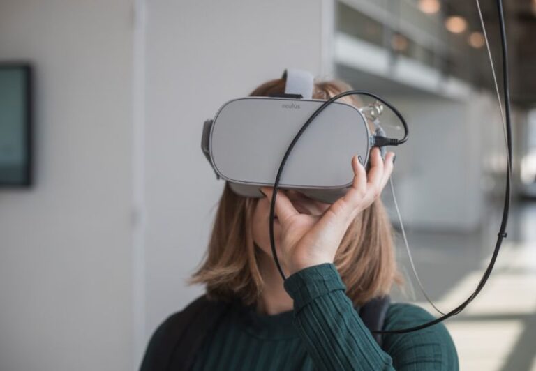 Innovations - woman in black sweater holding white and black vr goggles