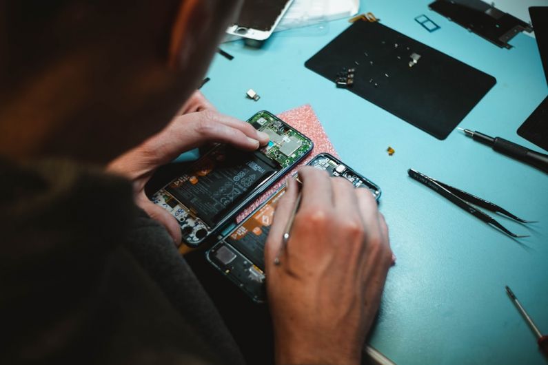 Repair - person repairing smartphones under a lighted table