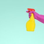 Cleaning - person holding yellow plastic spray bottle