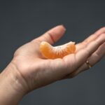 Acidity - a person holding an orange in their hand