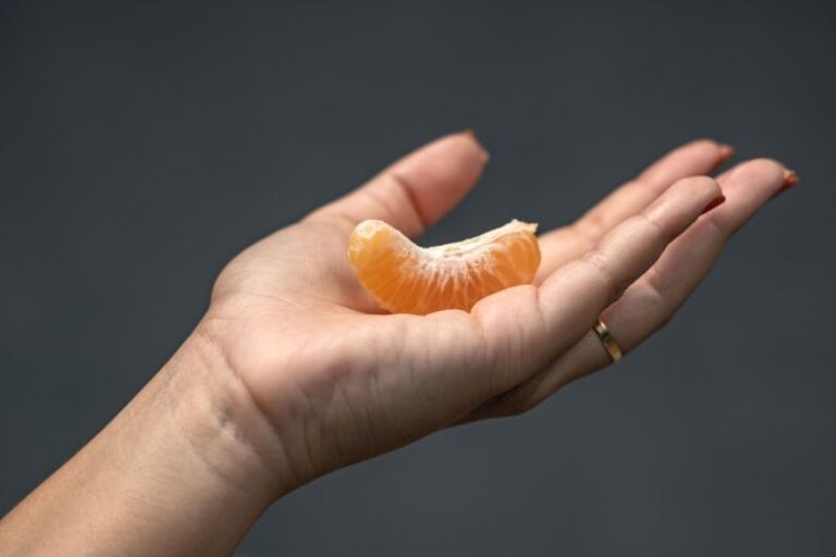 Acidity - a person holding an orange in their hand