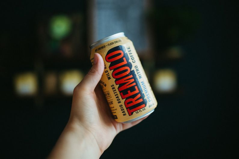 Nitro Coffee - a hand holding a can of food