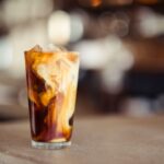 Unwashed Coffee - glass cup filled with ice latte on tabletop