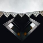 Symmetry - lowangle photography of brown and black high-rise building under cloudy sky