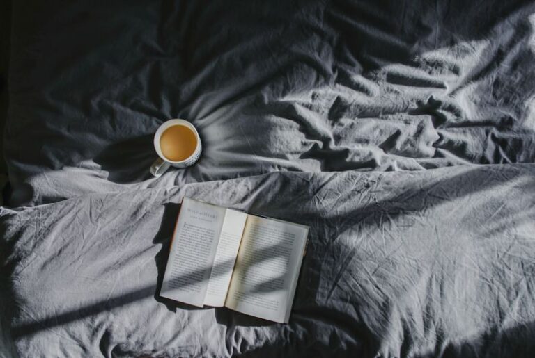 Coffee Rituals - white ceramic mug beside book on gray textile