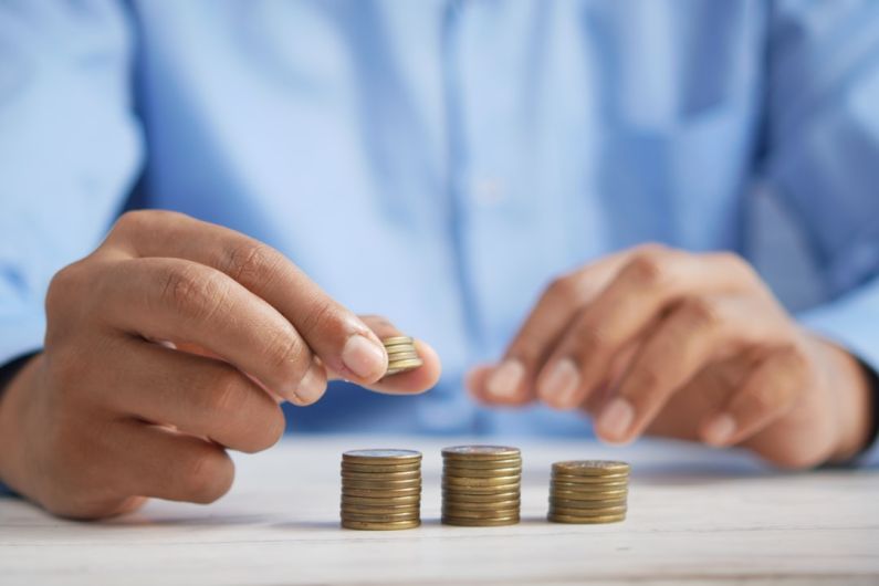 Economic Growth - a person stacking coins on top of a table