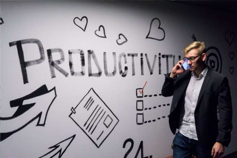 Productivity - man holding smartphone looking at productivity wall decor
