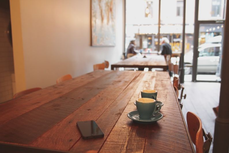 Café-Quality - two gray ceramic mugs on brown wooden dining table