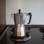 Percolator - gray moka pot on electric coil stove selective focus photo